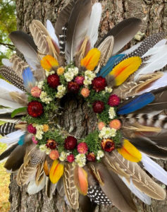 Kinship - ©Pat Tuholske - Multicolored feathers burrowed in a nest of strawflowers, globe amaranth, lichen and sweet everlasting. (Feather colors may vary slightly from picture.) 15” diameter $62